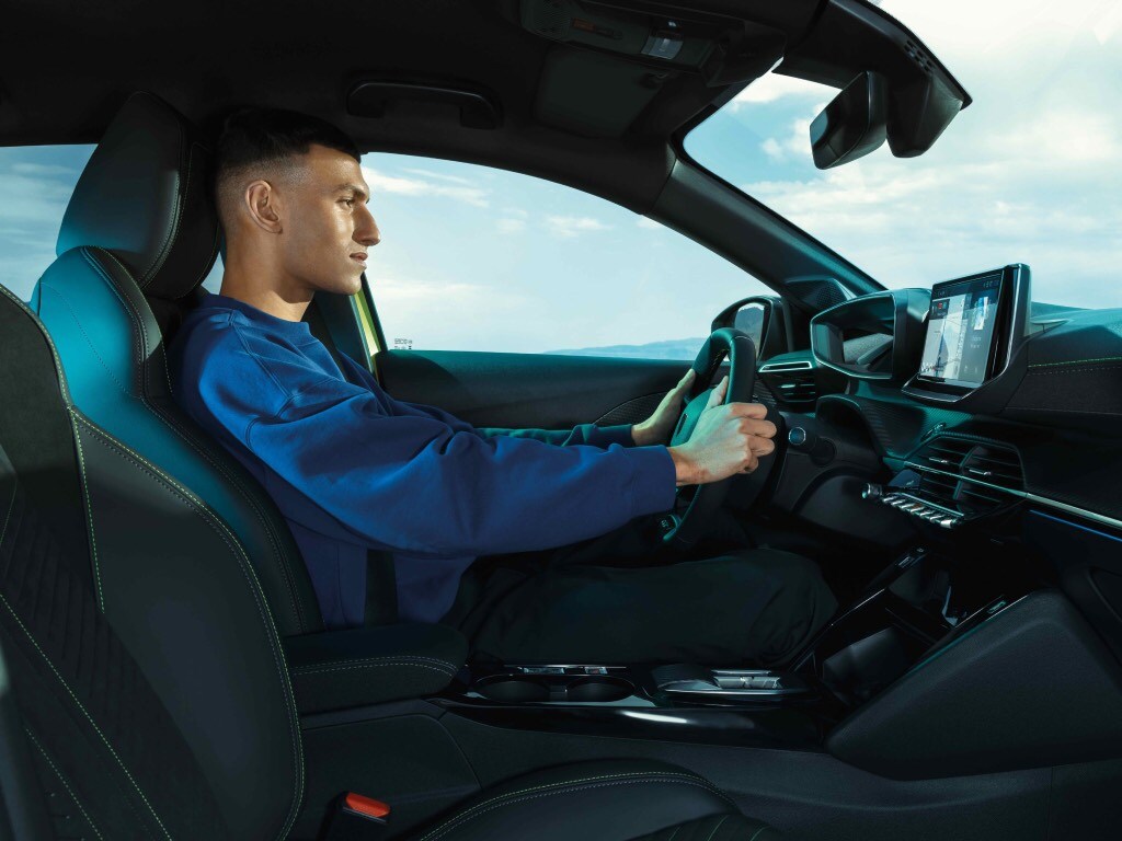 Man driving the new PEUGEOT E-208