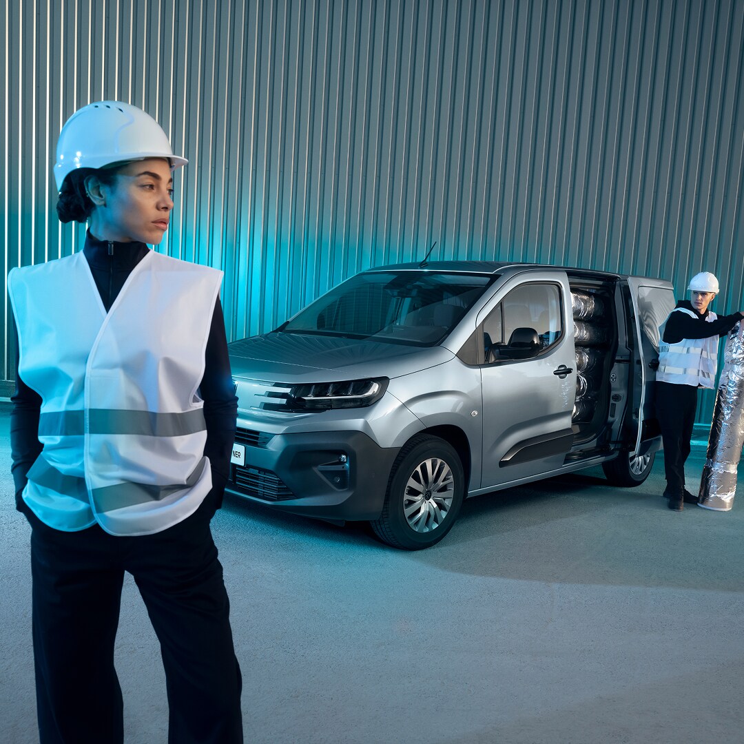 Woman standing in front of a PEUGEOT E-Partner